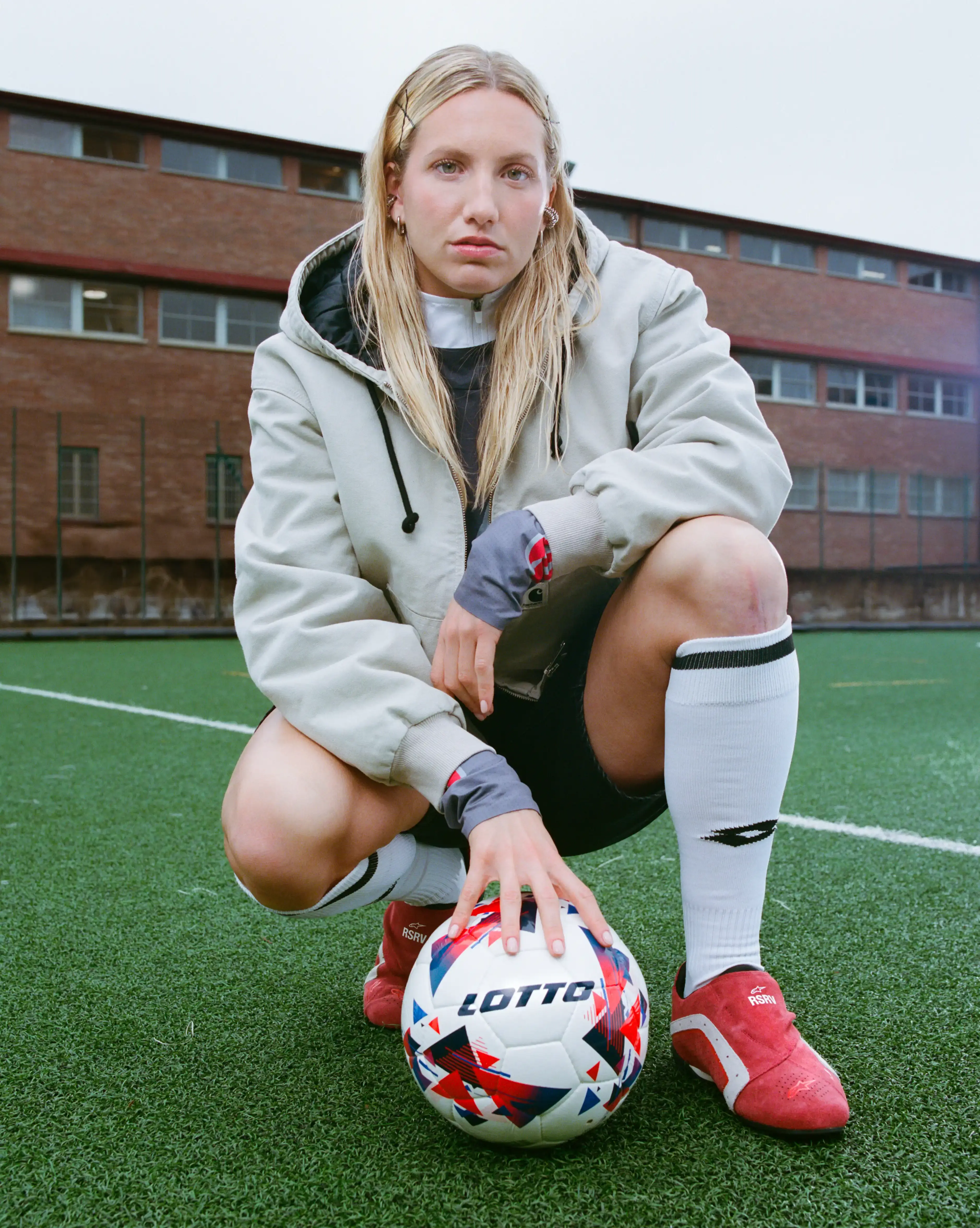 JACKET: CARHARTT WIP / LONG SLEEVE TOP & SHOES: ALPINESTARS RSRV / SHORTS: LEVI’S / SOCKS, FULL ZIP TOP & FOOTBALL: LOTTO SPORT ITALIA / EARRINGS: ARIANNA FABIANO JEWELRY JACKET: CARHARTT WIP / LONG SLEEVE TOP & SHOES: ALPINESTARS RSRV / SHORTS: LEVI’S / SOCKS, FULL ZIP TOP & FOOTBALL: LOTTO SPORT ITALIA / EARRINGS: ARIANNA FABIANO JEWELRY