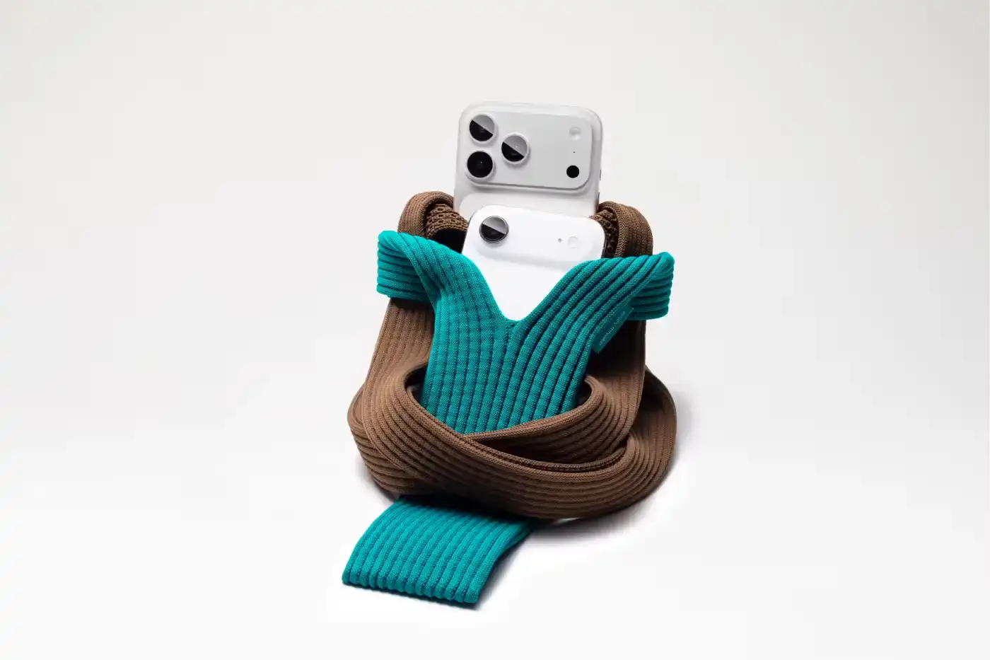 ISSEY MIYAKE AND APPLE LAUNCH IPHONE POCKET A 3D-knitted textile iPhone holder in a rectangular shape with ribbed pleated structure, available with short wrist strap or long crossbody strap in multiple colors, designed by Issey Miyake and Apple. (image 2 of 12)