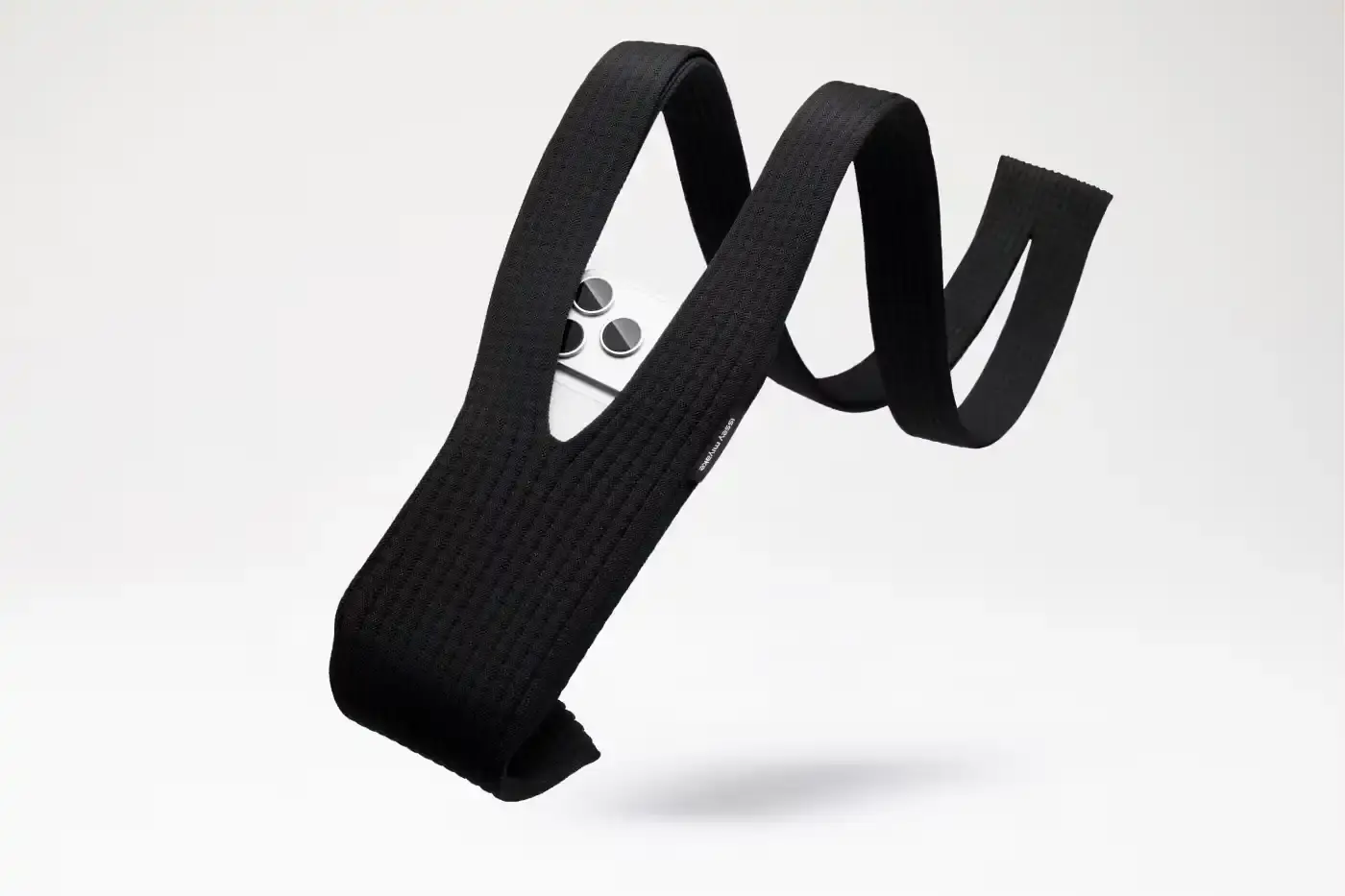 ISSEY MIYAKE AND APPLE LAUNCH IPHONE POCKET A 3D-knitted textile iPhone holder in a rectangular shape with ribbed pleated structure, available with short wrist strap or long crossbody strap in multiple colors, designed by Issey Miyake and Apple. (image 5 of 12)