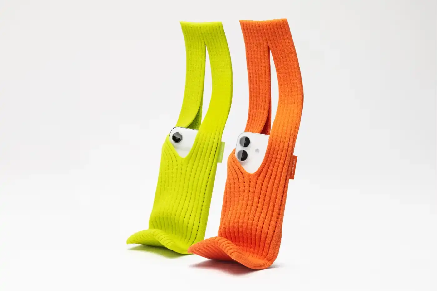 ISSEY MIYAKE AND APPLE LAUNCH IPHONE POCKET A 3D-knitted textile iPhone holder in a rectangular shape with ribbed pleated structure, available with short wrist strap or long crossbody strap in multiple colors, designed by Issey Miyake and Apple. (image 4 of 12)