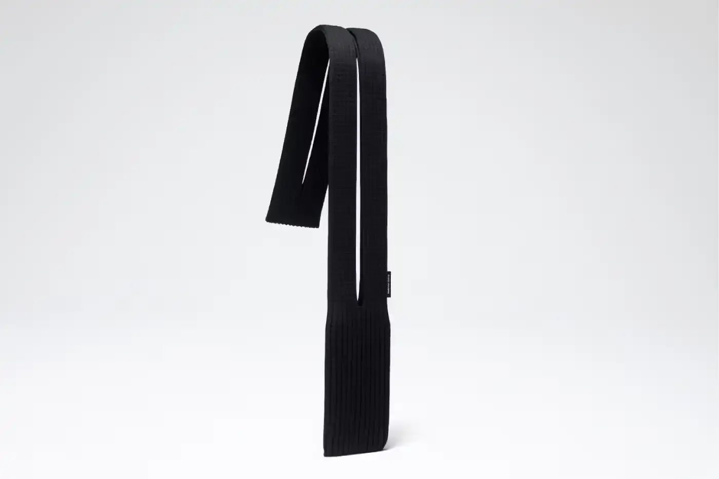 ISSEY MIYAKE AND APPLE LAUNCH IPHONE POCKET A 3D-knitted textile iPhone holder in a rectangular shape with ribbed pleated structure, available with short wrist strap or long crossbody strap in multiple colors, designed by Issey Miyake and Apple. (image 8 of 12)