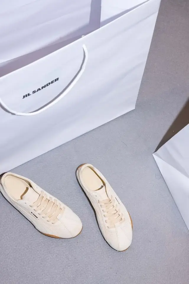 JIL SANDER AND PUMA PRESENT NEW H STREET SNEAKERS Studio image of Jil Sander and Puma low profile leather sneaker in ivory and dark brown with a thin rubber sole and minimal branding. (image 2 of 6)
