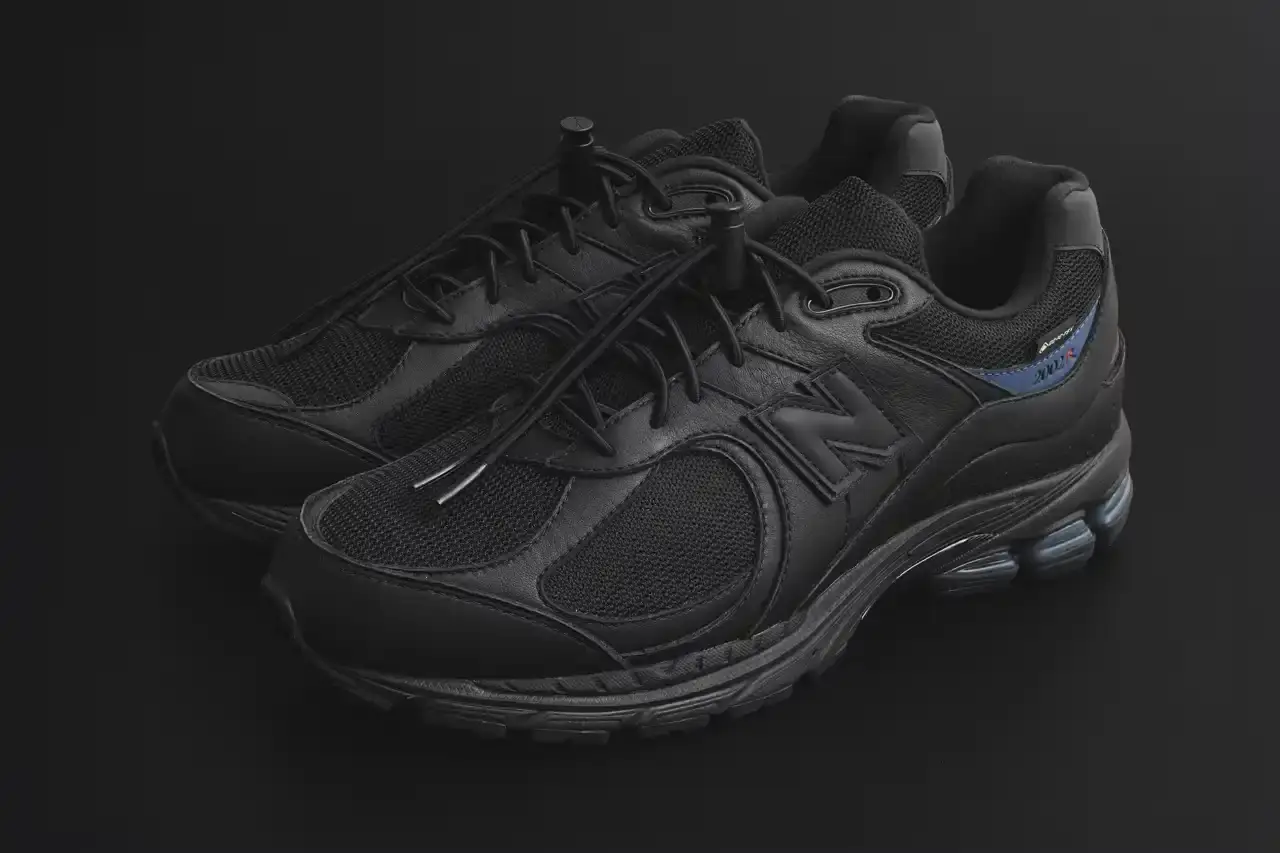 JJJJound JJJJound x New Balance 2002R GORE-TEX sneaker in all-black colorway, featuring mesh and leather construction with a subtle blue heel accent and GORE-TEX waterproof technology (image 3 of 4)