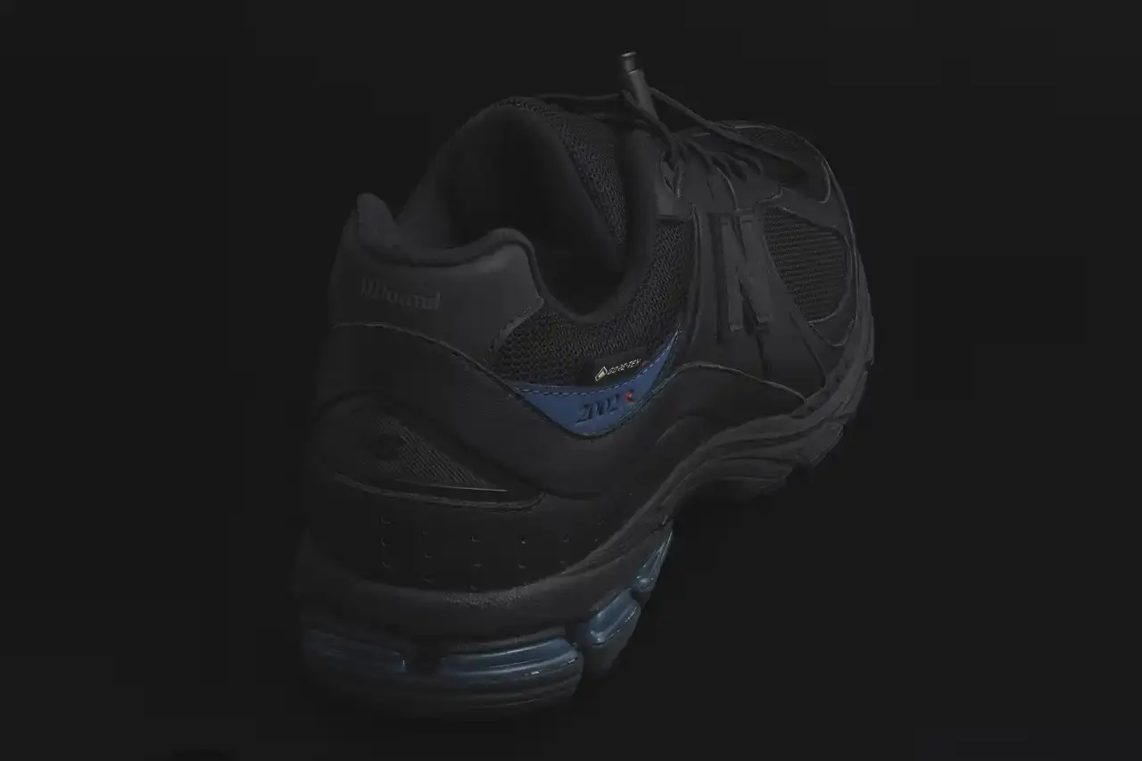 JJJJound JJJJound x New Balance 2002R GORE-TEX sneaker in all-black colorway, featuring mesh and leather construction with a subtle blue heel accent and GORE-TEX waterproof technology (image 4 of 4)