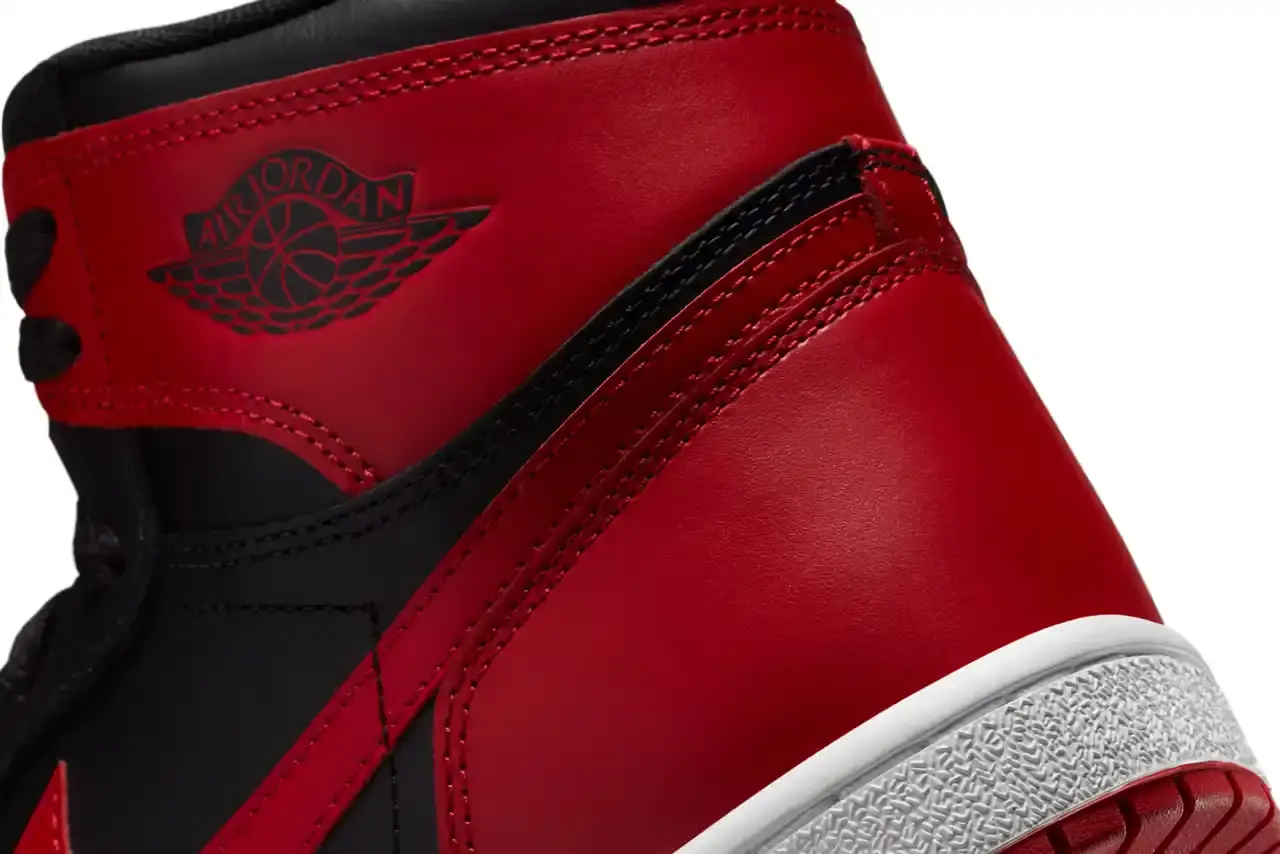 Nike Air Jordan 1 Hi '85 'Bred' sneaker in black and red leather with white midsole. Features original 1985 specifications including modified Swoosh shape, compact Wings logo, and elevated collar height. The shoe has a black leather base with red leather overlays, white Nike Swoosh, and red rubber outsole. (image 7 of 7)