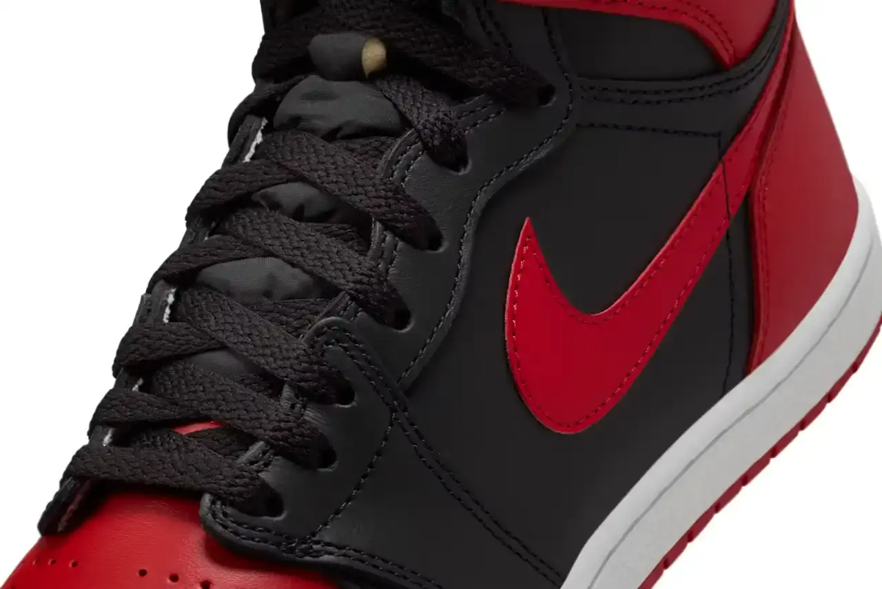 Nike Air Jordan 1 Hi '85 'Bred' sneaker in black and red leather with white midsole. Features original 1985 specifications including modified Swoosh shape, compact Wings logo, and elevated collar height. The shoe has a black leather base with red leather overlays, white Nike Swoosh, and red rubber outsole. (image 6 of 7)