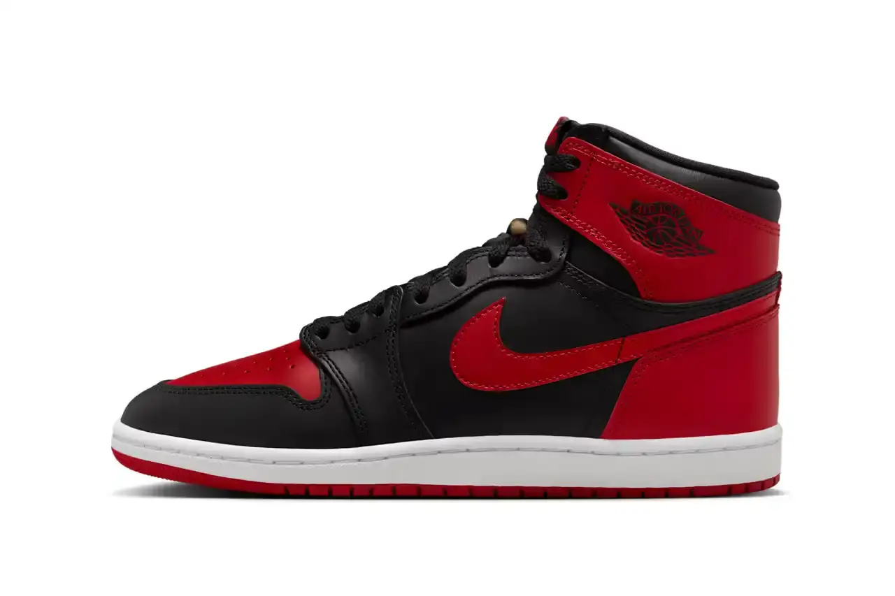 Nike Air Jordan 1 Hi '85 'Bred' sneaker in black and red leather with white midsole. Features original 1985 specifications including modified Swoosh shape, compact Wings logo, and elevated collar height. The shoe has a black leather base with red leather overlays, white Nike Swoosh, and red rubber outsole.