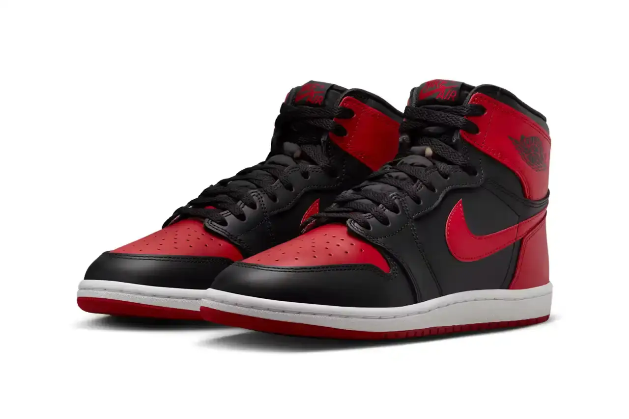 Nike Air Jordan 1 Hi '85 'Bred' sneaker in black and red leather with white midsole. Features original 1985 specifications including modified Swoosh shape, compact Wings logo, and elevated collar height. The shoe has a black leather base with red leather overlays, white Nike Swoosh, and red rubber outsole. (image 3 of 7)