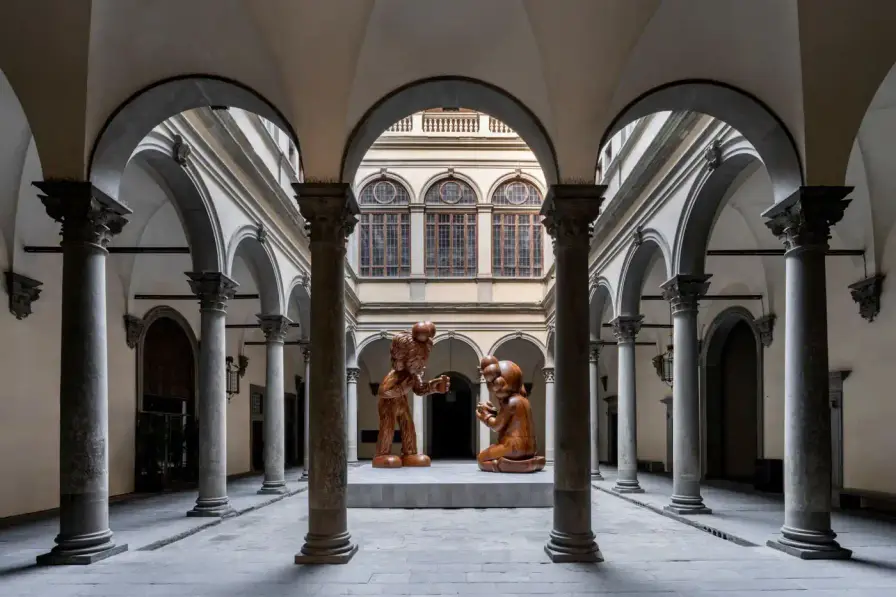 KAWS AT PALAZZO STROZZI IN FLORENCE KAWS installs large wooden sculptures at Florence's Palazzo Strozzi, featuring his signature characters in poses referencing Fra Angelico's 1433 Annunciation painting, exploring digital age themes through January 26, 2025. (image 2 of 3)
