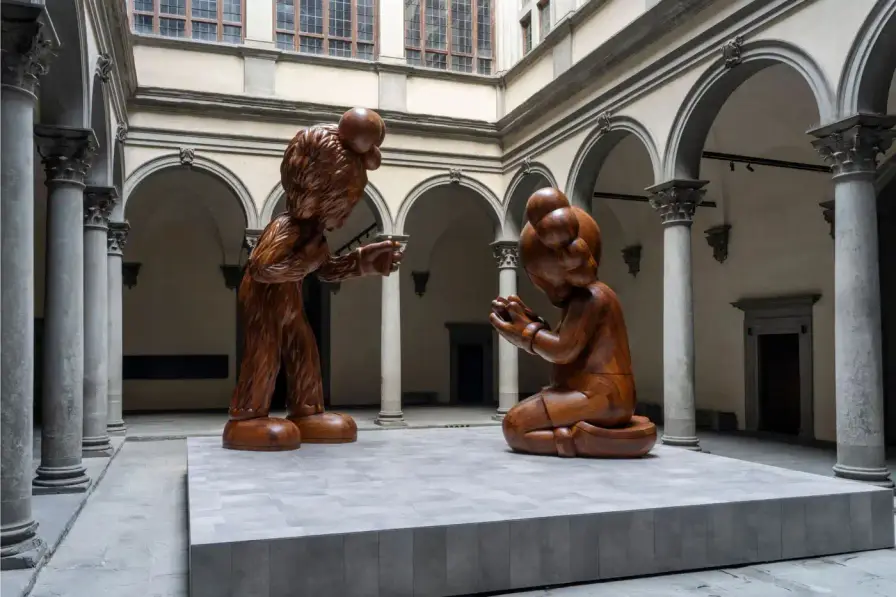 KAWS AT PALAZZO STROZZI IN FLORENCE KAWS installs large wooden sculptures at Florence's Palazzo Strozzi, featuring his signature characters in poses referencing Fra Angelico's 1433 Annunciation painting, exploring digital age themes through January 26, 2025. (image 3 of 3)