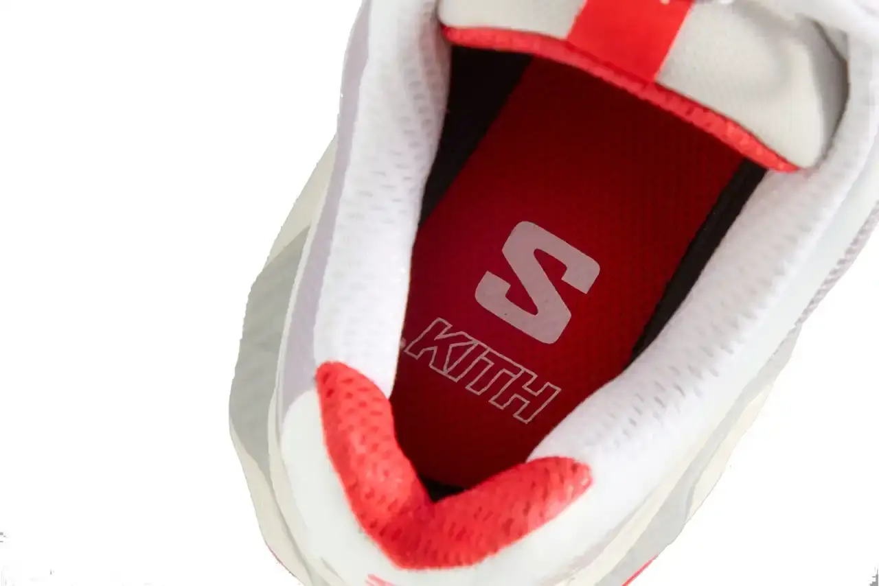 Kith Kith x Salomon XT-Voyager sneaker shown from side angle, featuring blue, grey, white and red colorway with distinctive zipper closure system.