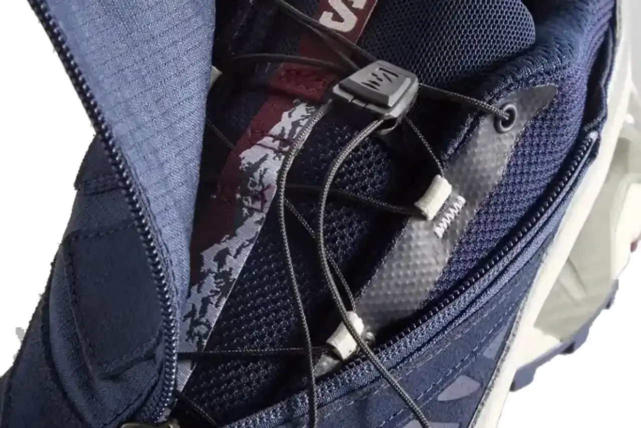 Kith Kith x Salomon XT-Voyager sneaker shown from side angle, featuring blue, grey, white and red colorway with distinctive zipper closure system. (image 10 of 12)