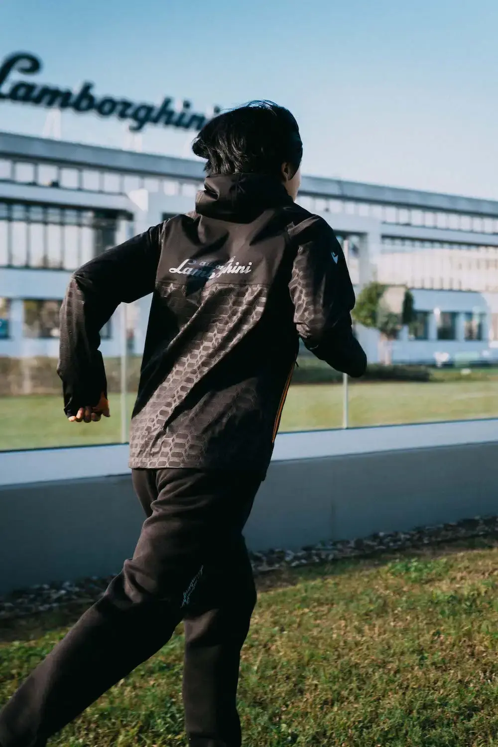 Lamborghini x Macron Lamborghini x Macron activewear collection featuring sports clothing in orange, blue, green, and purple, showcasing technical athletic wear inspired by luxury automotive design (image 4 of 5)