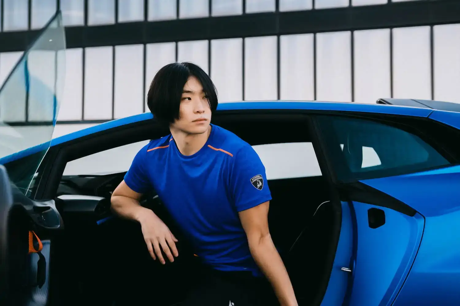 Lamborghini x Macron Lamborghini x Macron activewear collection featuring sports clothing in orange, blue, green, and purple, showcasing technical athletic wear inspired by luxury automotive design
