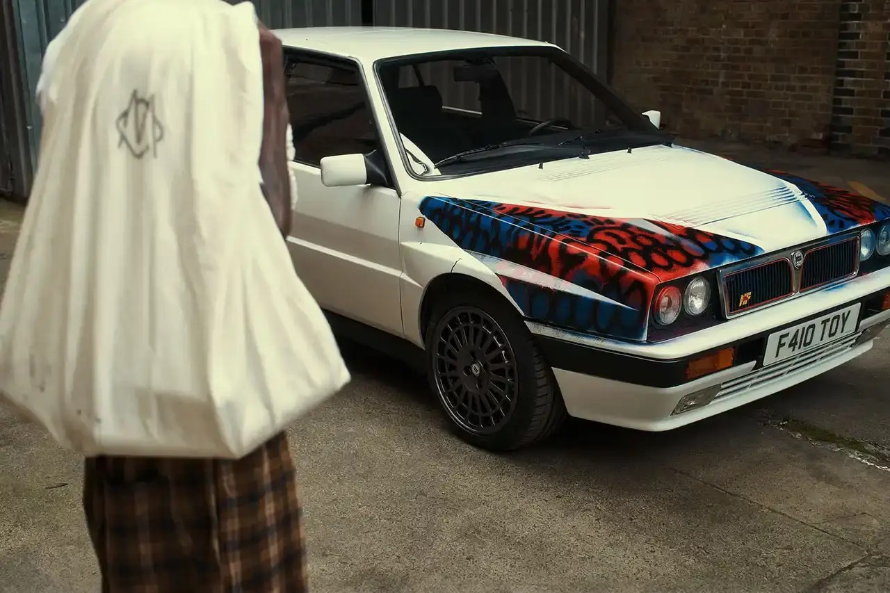 Spot A Lancia Delta Integrale rally car painted by artist Slawn, featuring bold artistic interpretations of the classic Martini racing livery with contemporary street art elements. (image 8 of 13)