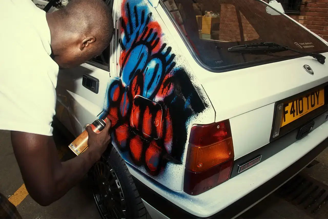Spot A Lancia Delta Integrale rally car painted by artist Slawn, featuring bold artistic interpretations of the classic Martini racing livery with contemporary street art elements.
