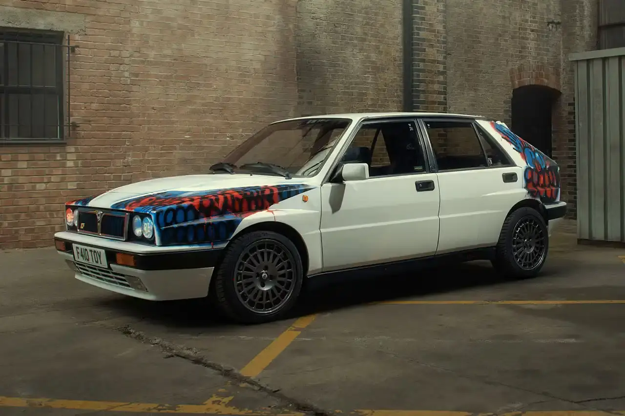 Spot A Lancia Delta Integrale rally car painted by artist Slawn, featuring bold artistic interpretations of the classic Martini racing livery with contemporary street art elements. (image 13 of 13)