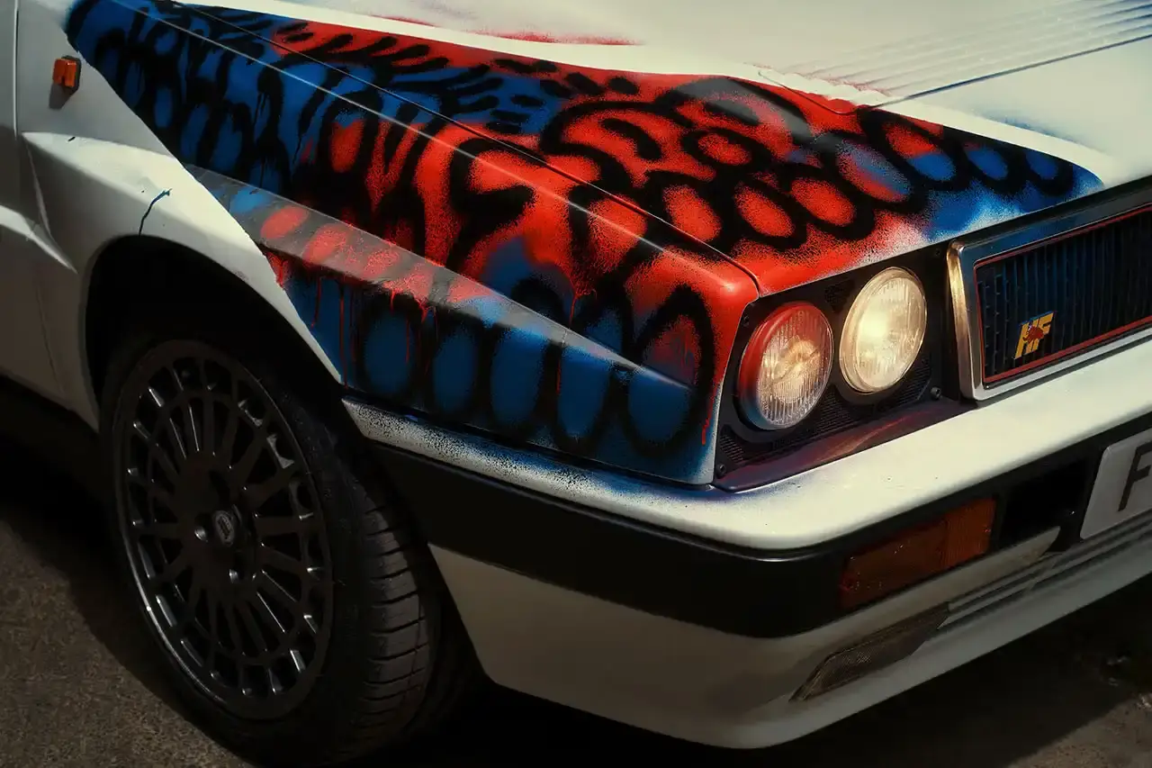 Spot A Lancia Delta Integrale rally car painted by artist Slawn, featuring bold artistic interpretations of the classic Martini racing livery with contemporary street art elements. (image 6 of 13)