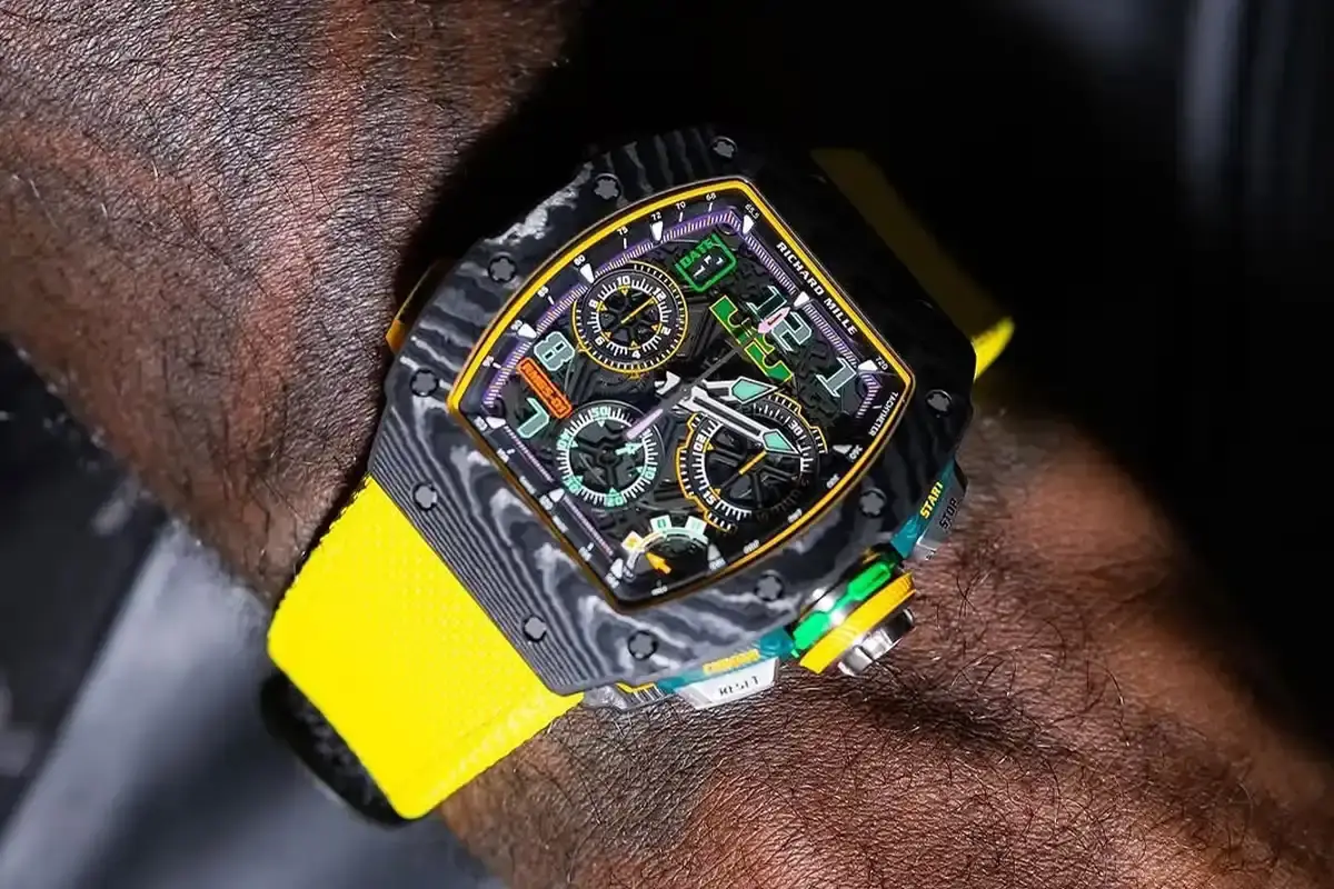 LEBRON JAMES UNVEILED RICHARD MILLE LAKERS WATCH image reports on a luxury watch collaboration between basketball player LeBron James and Swiss manufacturer Richard Mille. The timepiece incorporates Los Angeles Lakers team colors including yellow, purple, and green elements throughout its design. Key details include the $450,000 price point, production limitation of 150 units, and specific material choices like Quartz TPT construction. The watch features James' personal signature and logo placement as design elements. The article provides technical specifications about the watch's construction, materials, and distribution through authorized dealers.