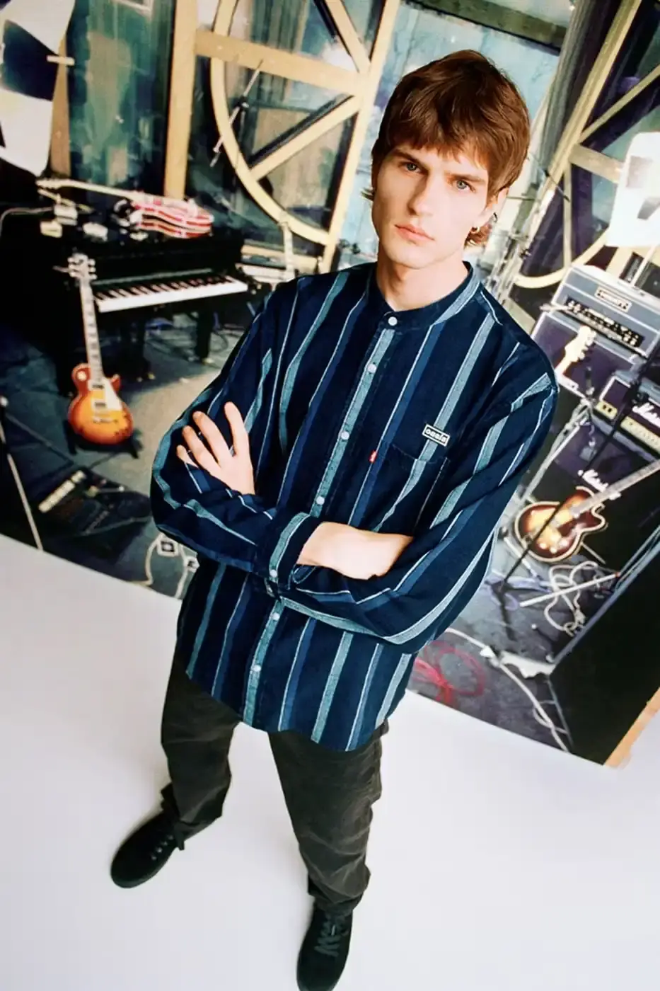 LEVI'S OASIS COLLECTION MARKS BAND'S RETURN image of Levi's new clothing collection inspired by British rock band Oasis, featuring T-shirts with vintage logos and denim pieces including Liam Gallagher's signature parka style. Collection currently available in Europe with worldwide release planned for 2025 (image 9 of 15)
