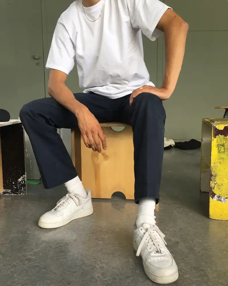 HOW SHAI DATAUKER REDEFINES CLOTHING, IDENTITY, AND DAILY LIFE Shai Datauker wearing his daily uniform-a bright red Adidas tracksuit and white t-shirt-sitting in a minimalist interior during an interview about fashion and identity. (image 2 of 5)