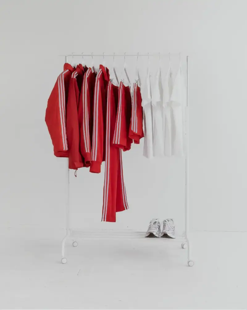 HOW SHAI DATAUKER REDEFINES CLOTHING, IDENTITY, AND DAILY LIFE Shai Datauker wearing his daily uniform-a bright red Adidas tracksuit and white t-shirt-sitting in a minimalist interior during an interview about fashion and identity. (image 5 of 5)