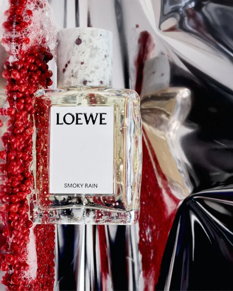 LOEWE PERFUMES EXPANDS CRAFTED COLLECTION Image series showing still-life perfume bottles with granite caps alongside raw botanical ingredients, pigment powders, and fresh citrus slices. (image 8 of 10)