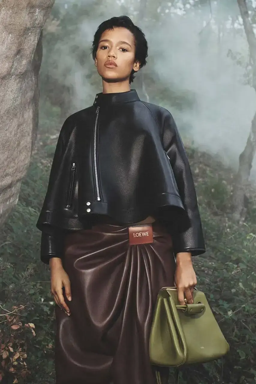 LOEWE Drew Starkey standing in a gradient brown calfskin coat against a rocky mountain backdrop