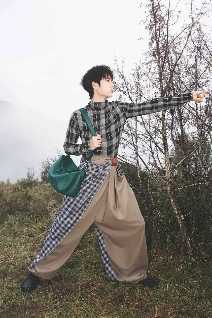 LOEWE Wang Yibo wearing draped cotton and wool check trousers with a backward-styled shirt in the Spanish mountains