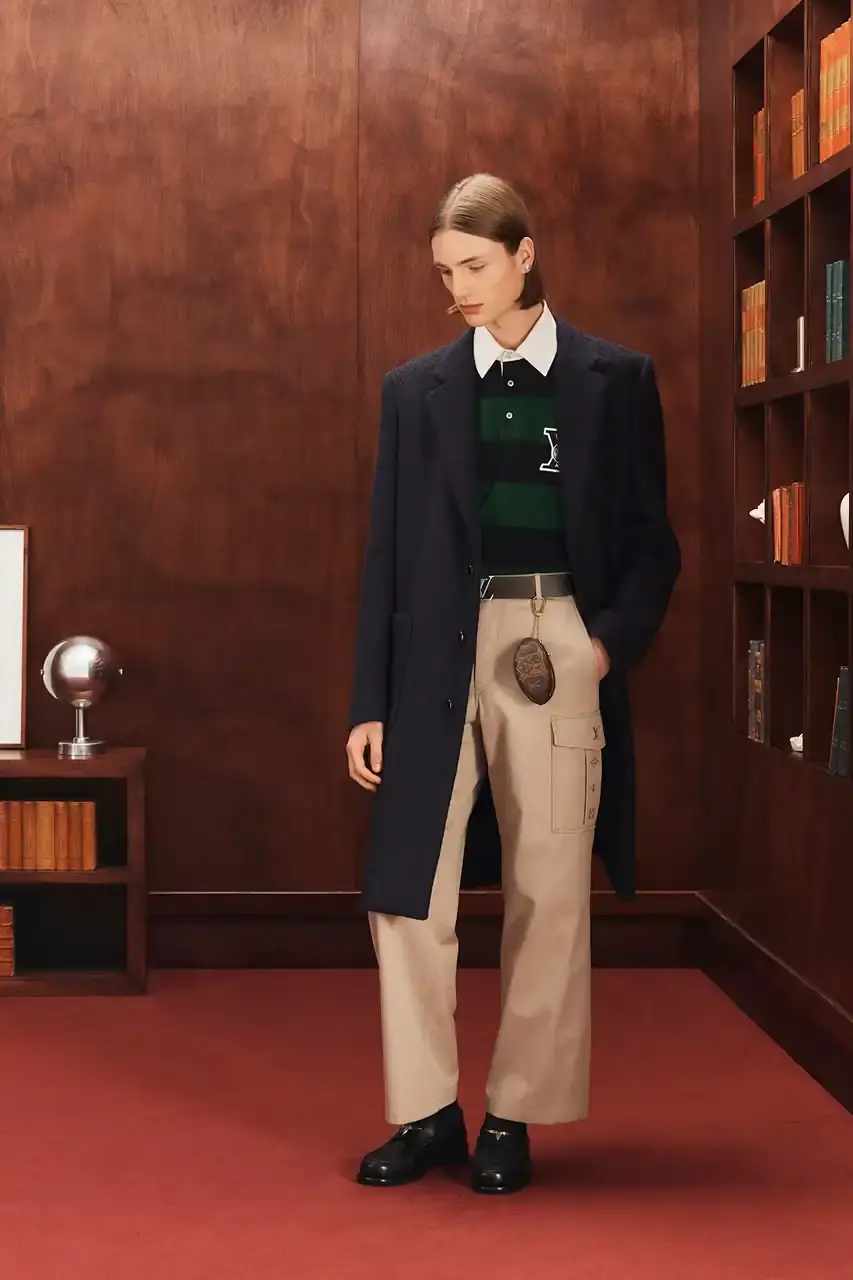 LOUIS VUITTON FALL 2026 MENSWEAR PREVIEW image about Louis Vuitton's upcoming Fall 2026 menswear collection designed by Pharrell Williams. The piece discusses the collection's American collegiate inspiration, key design elements including tartan patterns and heritage stripes, outerwear focus, and September release timeline. Contains detailed descriptions of clothing items, patterns, materials, and accessories without accompanying images. (image 20 of 29)