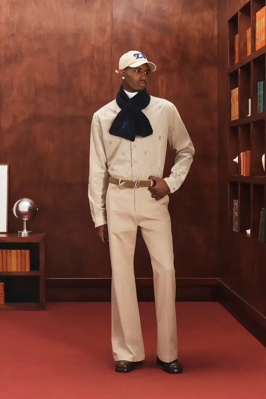 LOUIS VUITTON FALL 2026 MENSWEAR PREVIEW image about Louis Vuitton's upcoming Fall 2026 menswear collection designed by Pharrell Williams. The piece discusses the collection's American collegiate inspiration, key design elements including tartan patterns and heritage stripes, outerwear focus, and September release timeline. Contains detailed descriptions of clothing items, patterns, materials, and accessories without accompanying images. (image 5 of 29)