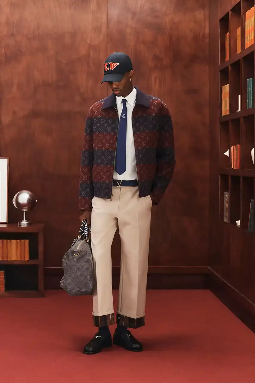 LOUIS VUITTON FALL 2026 MENSWEAR PREVIEW image about Louis Vuitton's upcoming Fall 2026 menswear collection designed by Pharrell Williams. The piece discusses the collection's American collegiate inspiration, key design elements including tartan patterns and heritage stripes, outerwear focus, and September release timeline. Contains detailed descriptions of clothing items, patterns, materials, and accessories without accompanying images. (image 25 of 29)