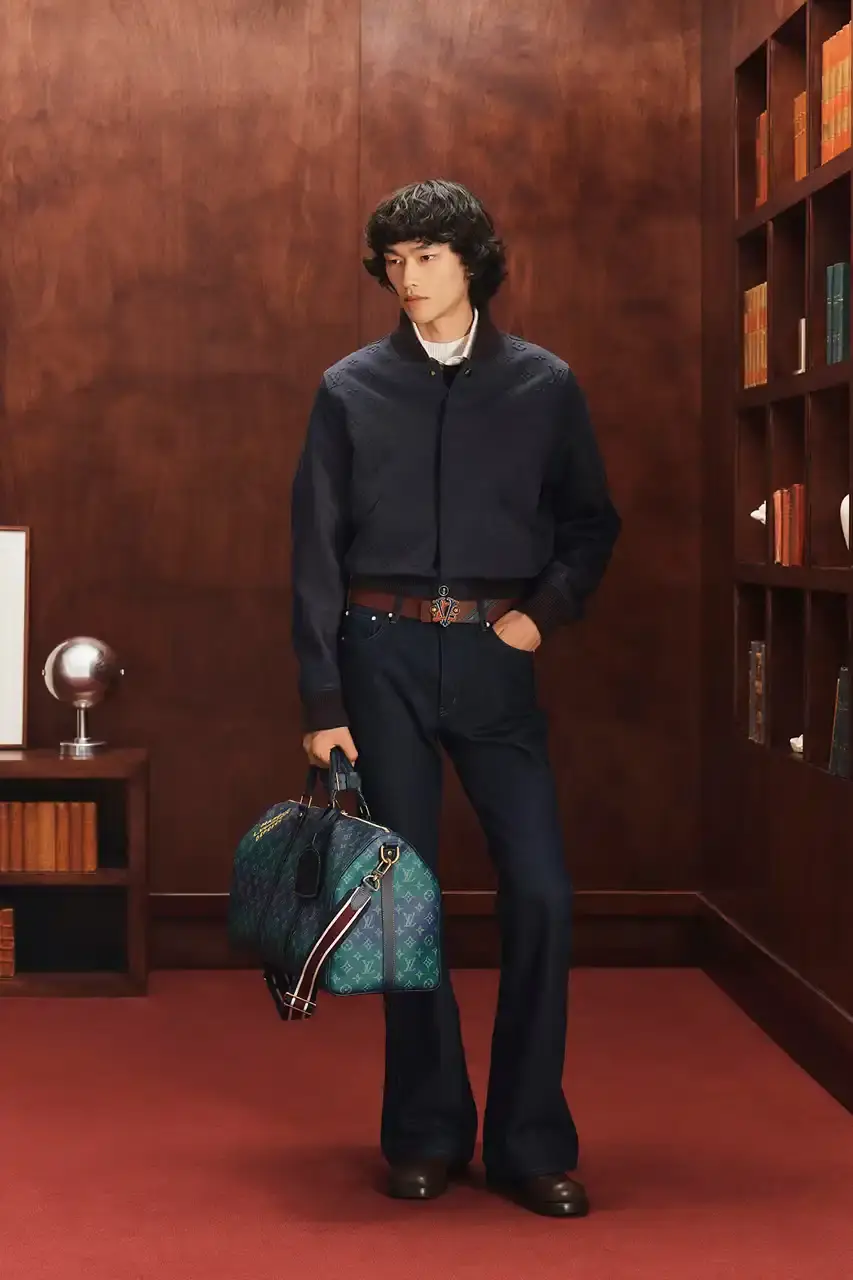 LOUIS VUITTON FALL 2026 MENSWEAR PREVIEW image about Louis Vuitton's upcoming Fall 2026 menswear collection designed by Pharrell Williams. The piece discusses the collection's American collegiate inspiration, key design elements including tartan patterns and heritage stripes, outerwear focus, and September release timeline. Contains detailed descriptions of clothing items, patterns, materials, and accessories without accompanying images. (image 18 of 29)