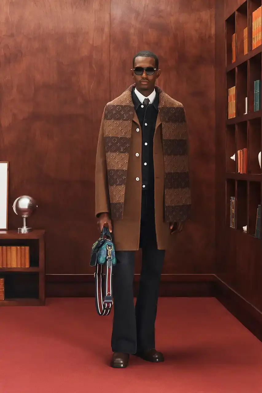 LOUIS VUITTON FALL 2026 MENSWEAR PREVIEW image about Louis Vuitton's upcoming Fall 2026 menswear collection designed by Pharrell Williams. The piece discusses the collection's American collegiate inspiration, key design elements including tartan patterns and heritage stripes, outerwear focus, and September release timeline. Contains detailed descriptions of clothing items, patterns, materials, and accessories without accompanying images. (image 4 of 29)