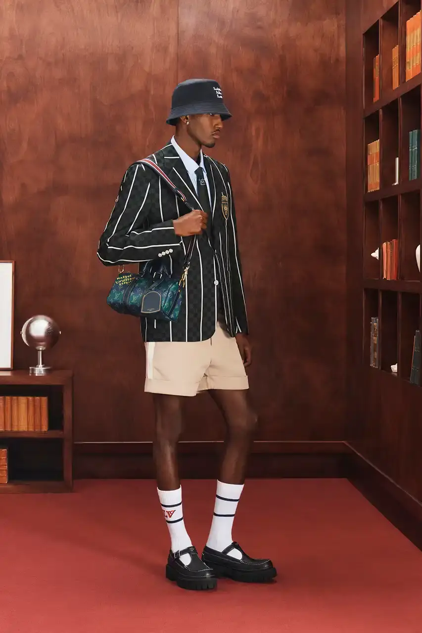 LOUIS VUITTON FALL 2026 MENSWEAR PREVIEW image about Louis Vuitton's upcoming Fall 2026 menswear collection designed by Pharrell Williams. The piece discusses the collection's American collegiate inspiration, key design elements including tartan patterns and heritage stripes, outerwear focus, and September release timeline. Contains detailed descriptions of clothing items, patterns, materials, and accessories without accompanying images. (image 27 of 29)