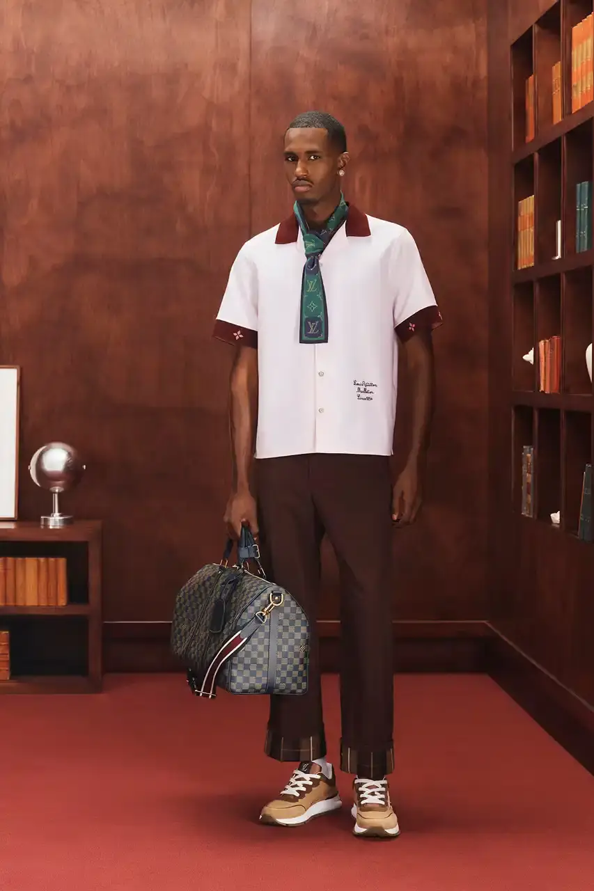 LOUIS VUITTON FALL 2026 MENSWEAR PREVIEW image about Louis Vuitton's upcoming Fall 2026 menswear collection designed by Pharrell Williams. The piece discusses the collection's American collegiate inspiration, key design elements including tartan patterns and heritage stripes, outerwear focus, and September release timeline. Contains detailed descriptions of clothing items, patterns, materials, and accessories without accompanying images. (image 28 of 29)