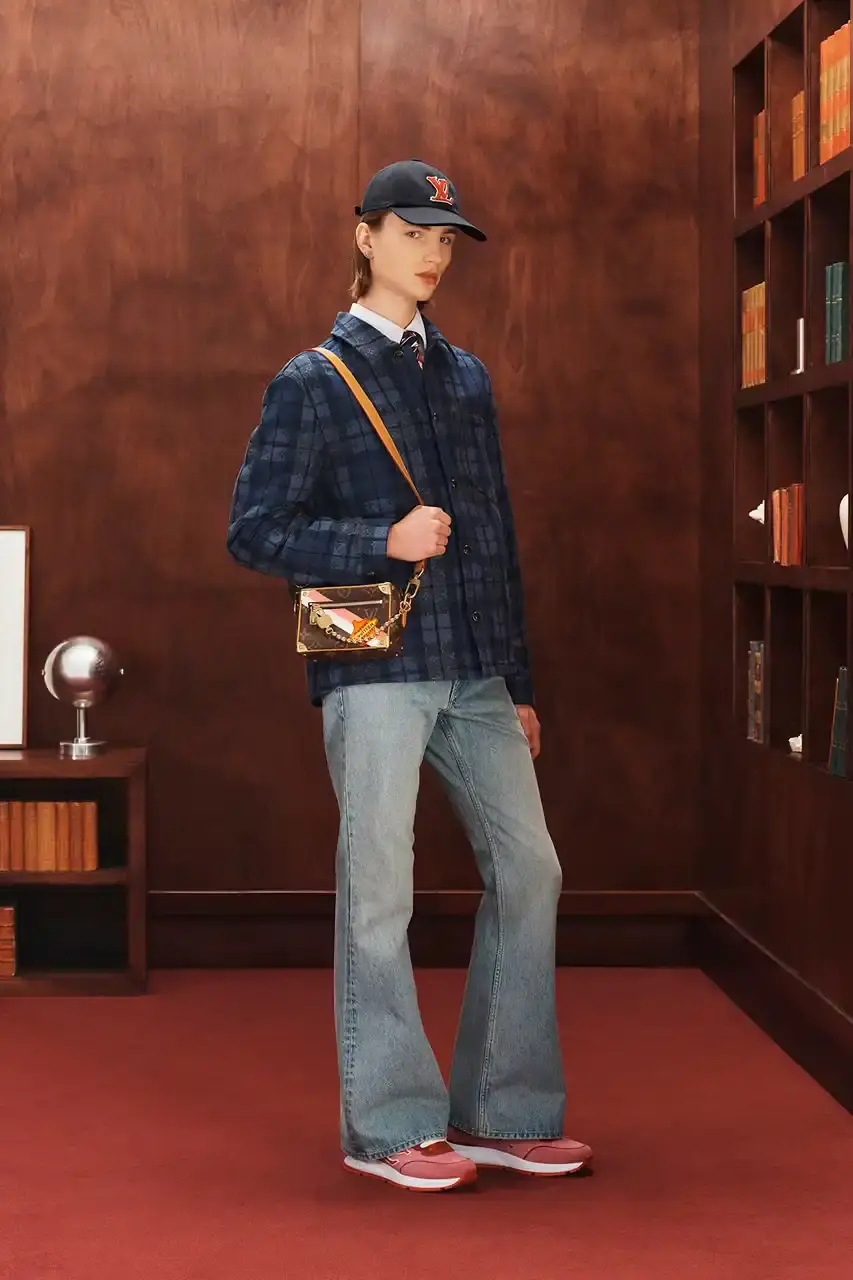 LOUIS VUITTON FALL 2026 MENSWEAR PREVIEW image about Louis Vuitton's upcoming Fall 2026 menswear collection designed by Pharrell Williams. The piece discusses the collection's American collegiate inspiration, key design elements including tartan patterns and heritage stripes, outerwear focus, and September release timeline. Contains detailed descriptions of clothing items, patterns, materials, and accessories without accompanying images. (image 21 of 29)