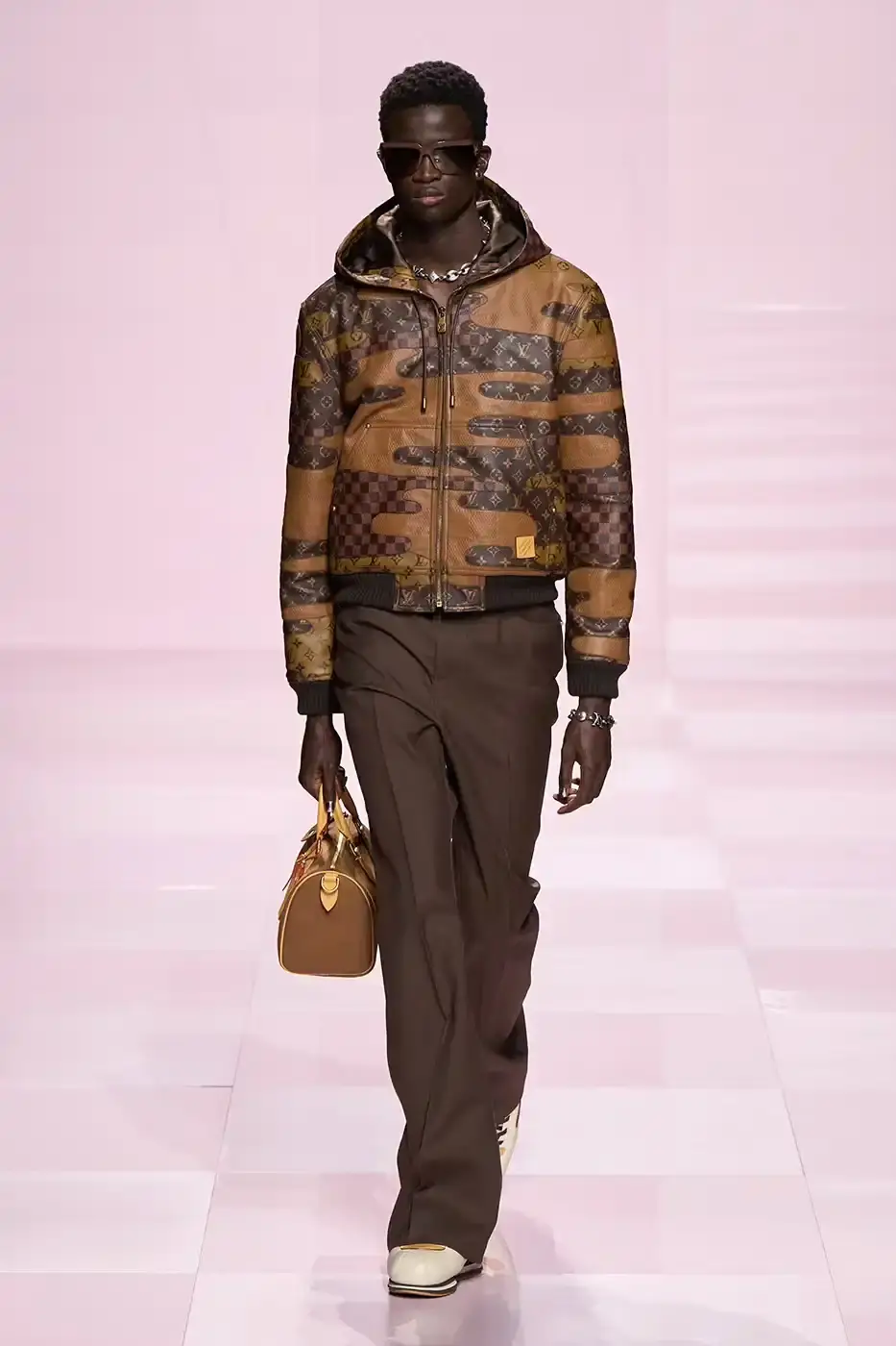 Louis Vuitton Louis Vuitton's Fall/Winter 2025 menswear collection, detailing the creative collaboration between Pharrell Williams and NIGO, featuring streetwear elements, Japanese craftsmanship, and French luxury design, with references to historical brand elements and new patterns. (image 20 of 23)