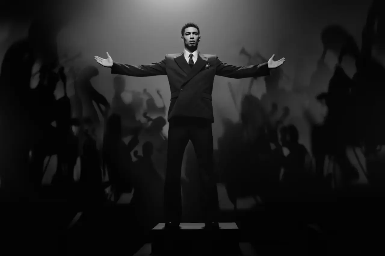 Jude Bellingham, rising football star, wearing a Louis Vuitton double-breasted suit and monogrammed coat, standing confidently as the brand's newest ambassador.