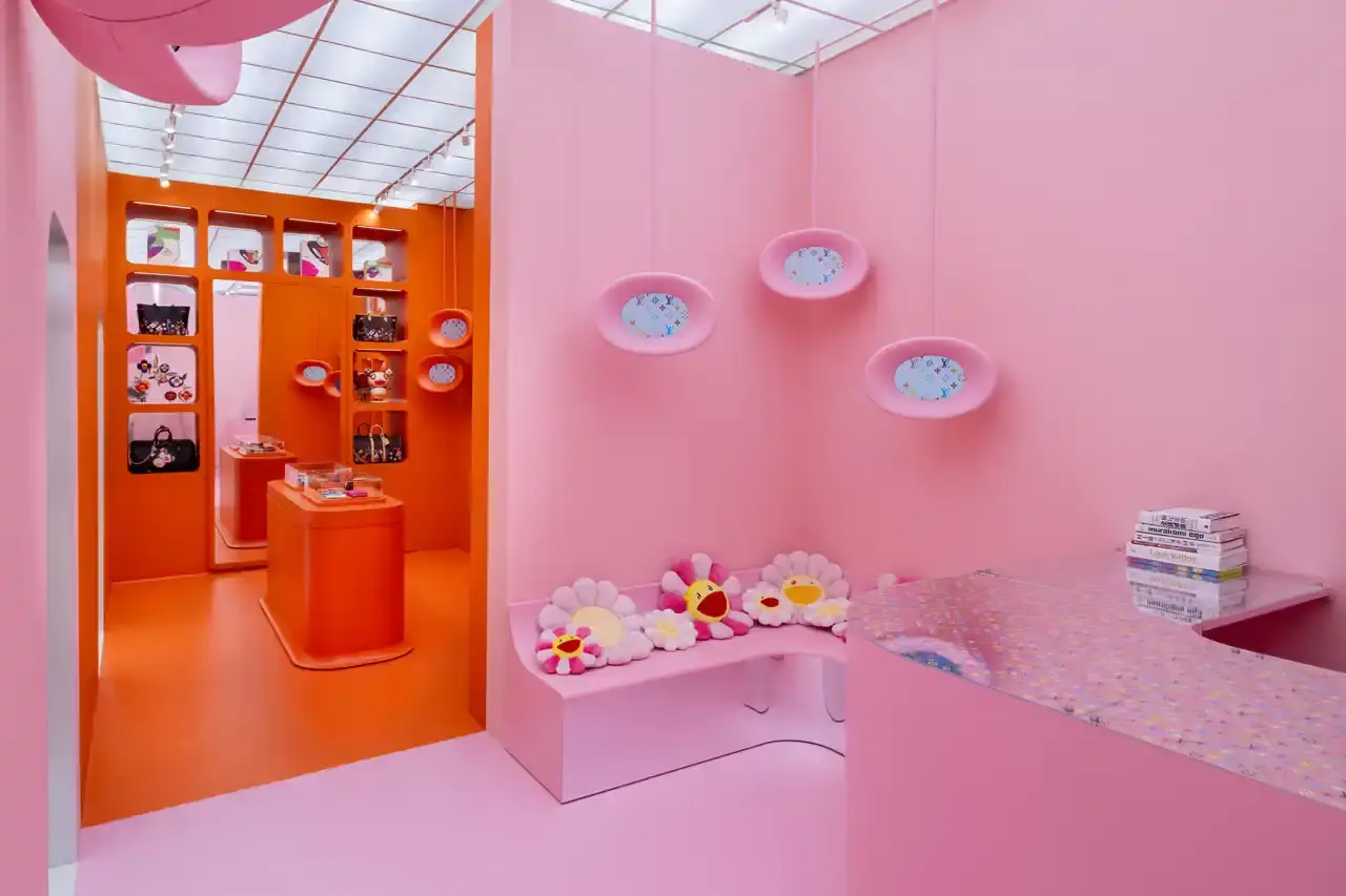 Brad Dickson Louis Vuitton's SoHo boutique exterior features Takashi Murakami's colorful flower motifs and rainbow monogram patterns. The multi-level space includes exhibition areas displaying archival pieces, a downstairs cinema, retail section with new collection items, and a themed café with custom-designed cups. (image 5 of 7)