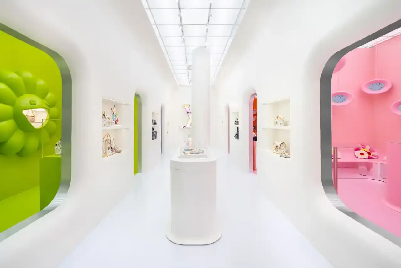 Brad Dickson Louis Vuitton's SoHo boutique exterior features Takashi Murakami's colorful flower motifs and rainbow monogram patterns. The multi-level space includes exhibition areas displaying archival pieces, a downstairs cinema, retail section with new collection items, and a themed café with custom-designed cups. (image 4 of 7)