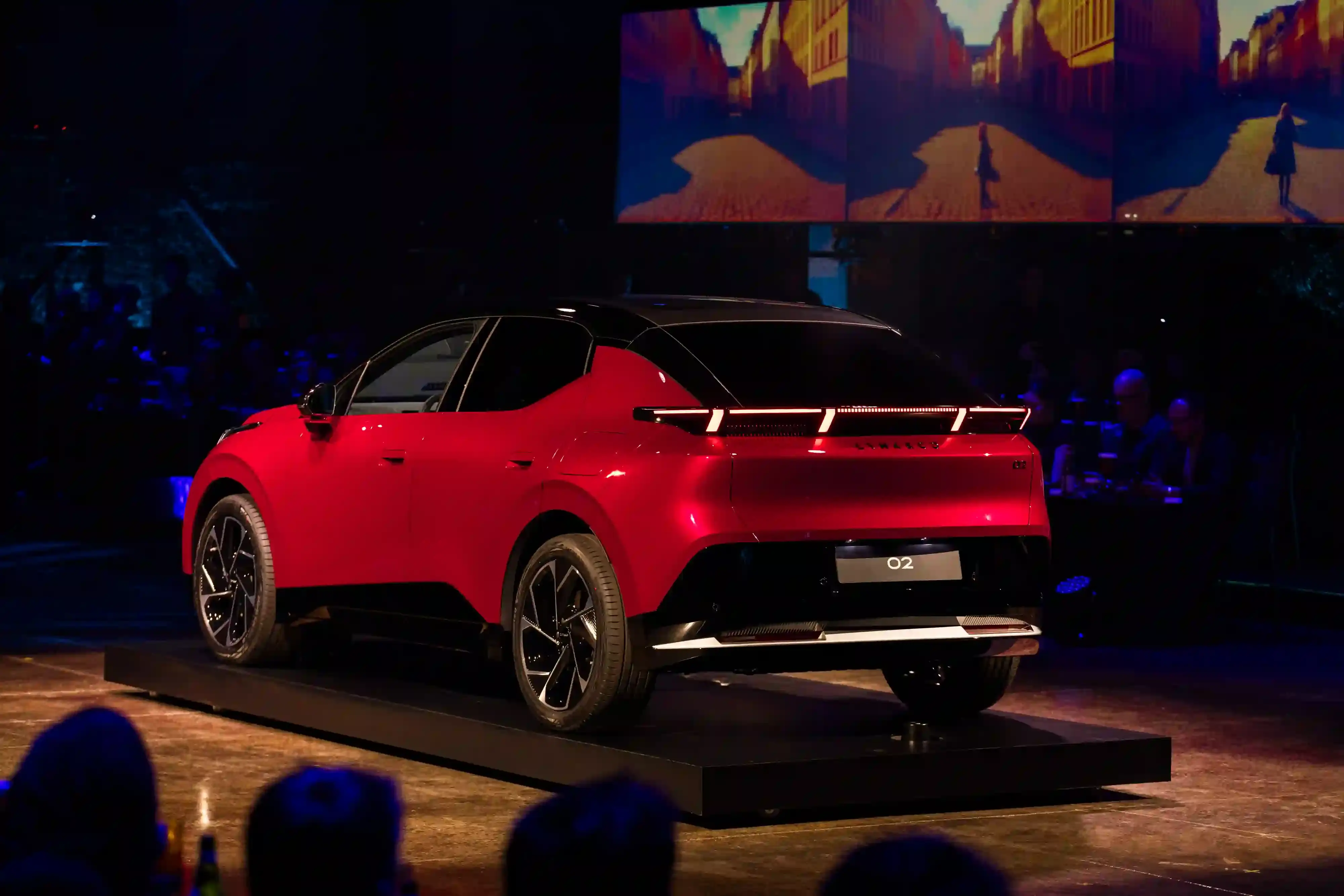 LYNK & CO LAUNCHES 02: FIRST ELECTRIC VEHICLE FOR EUROPEAN MARKET Lynk & Co 02 electric vehicle displayed at Spazio Antologico in Milan, showing the car's front three-quarter view against architectural backdrop