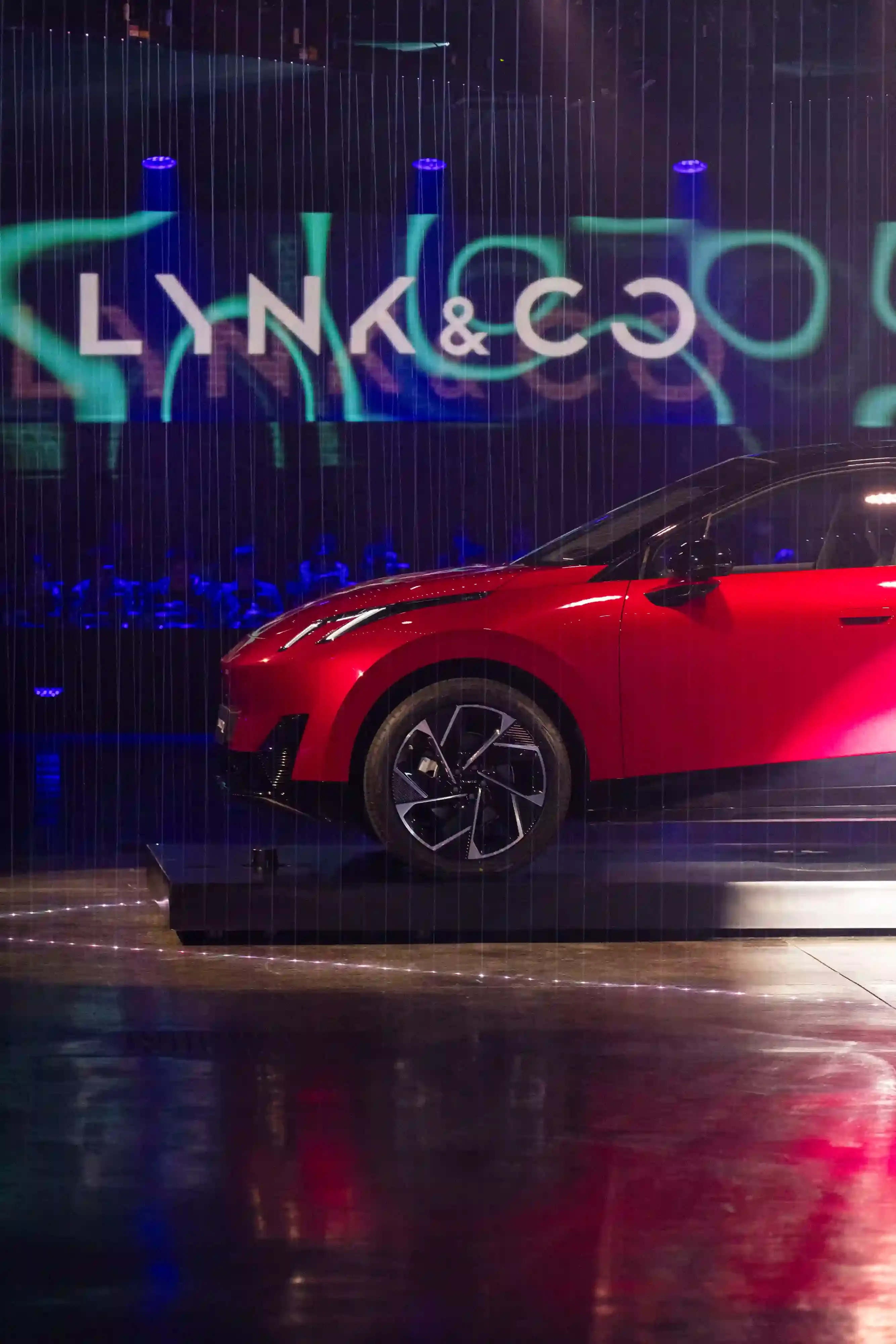 LYNK & CO LAUNCHES 02: FIRST ELECTRIC VEHICLE FOR EUROPEAN MARKET Lynk & Co 02 electric vehicle displayed at Spazio Antologico in Milan, showing the car's front three-quarter view against architectural backdrop (image 4 of 4)