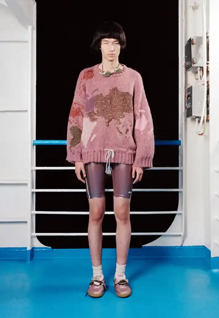 MAGLIANO SHOWS SS26 COLLECTION VIA FERRY FILM image about Italian designer Luca Magliano's Spring/Summer 2026 menswear collection, presented as a film aboard a ferry during Milan Fashion Week. The collection features camping and nomadic influences, with repurposed materials, loose silhouettes, and collaborative footwear including Beja soccer sneakers and 1900s-inspired boots. Shoot by Leonardo Scotti. (image 6 of 16)