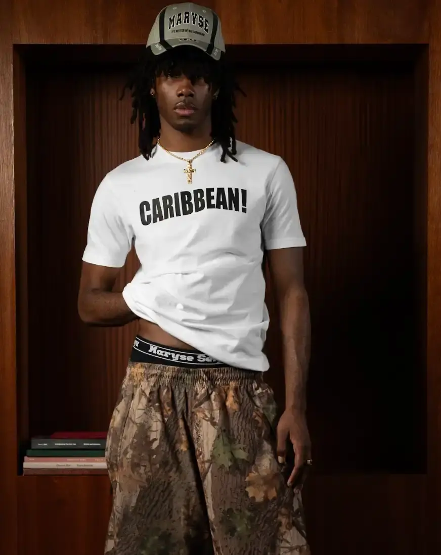 MARYSE SEIGU HONORS OLYMPIC PIONEER IN NEW COLLECTION image about the launch of Maryse Seigu's third fashion collection "CANGUIO S/S 25," which pays tribute to Marlene Canguio, the first woman from Guadeloupe to compete in the Olympic Games. The piece discusses the 13-item athletic-inspired collection that combines Caribbean cultural heritage with contemporary urban fashion, key pieces named after notable Afro-Caribbean athletes, and details about the brand's visual storytelling approach. The article includes information about a launch event in New York on May 23, 2025, and online availability starting May 29, 2025. (image 5 of 6)