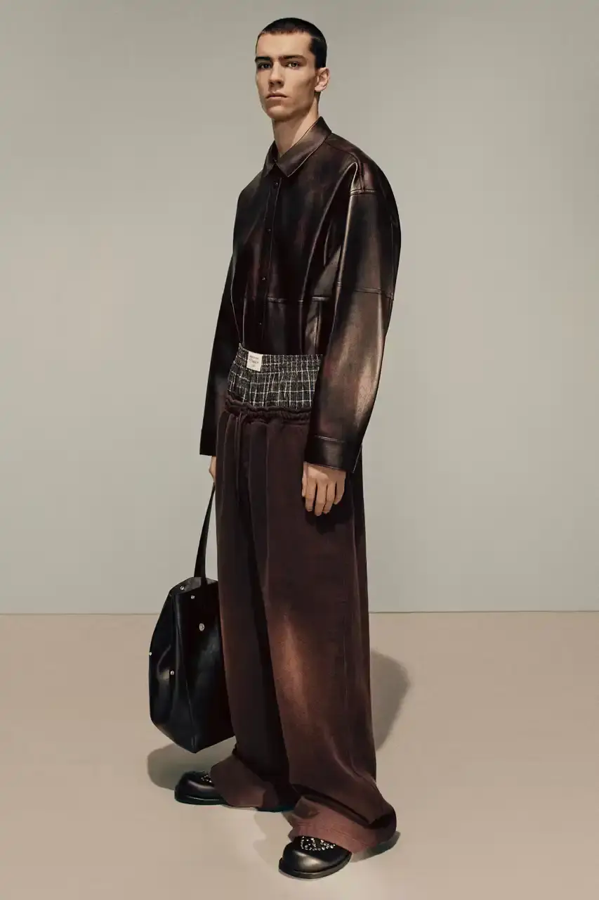 Acne Studios Male model wearing a gray tweed jacket over pink athletic tank top, paired with blue jeans and heart-shaped Acne Studios belt buckle (image 15 of 24)