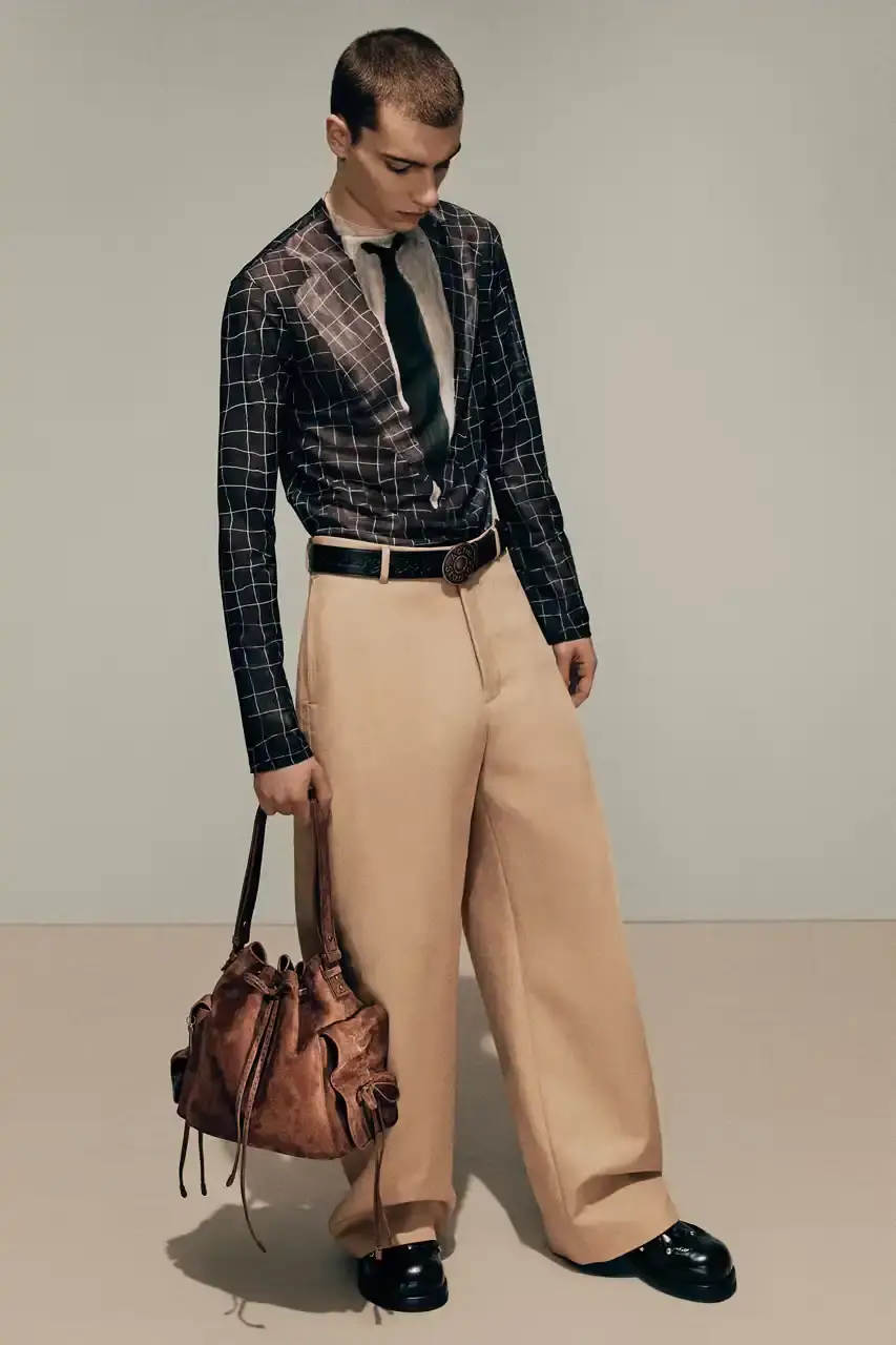 Acne Studios Male model wearing a gray tweed jacket over pink athletic tank top, paired with blue jeans and heart-shaped Acne Studios belt buckle (image 4 of 24)
