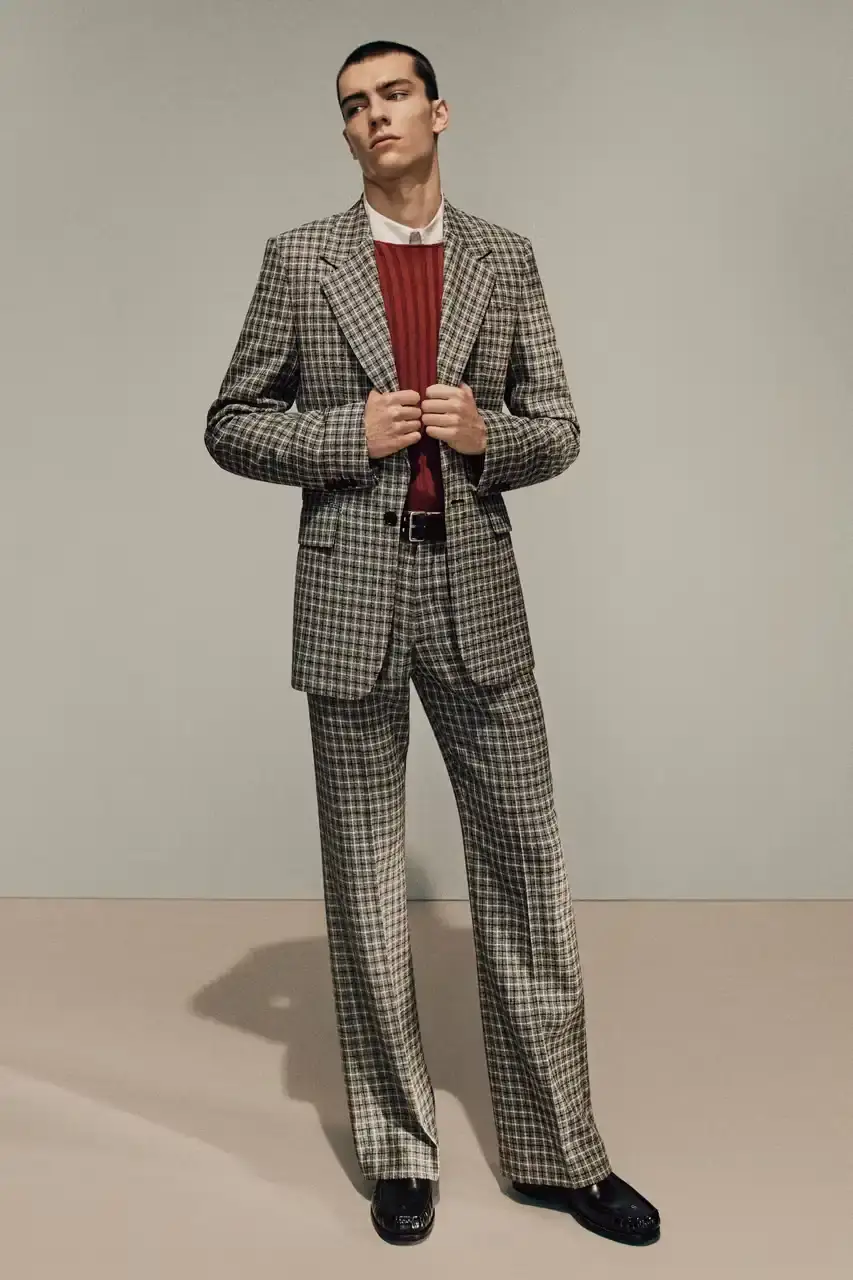 Acne Studios Male model wearing a gray tweed jacket over pink athletic tank top, paired with blue jeans and heart-shaped Acne Studios belt buckle (image 13 of 24)