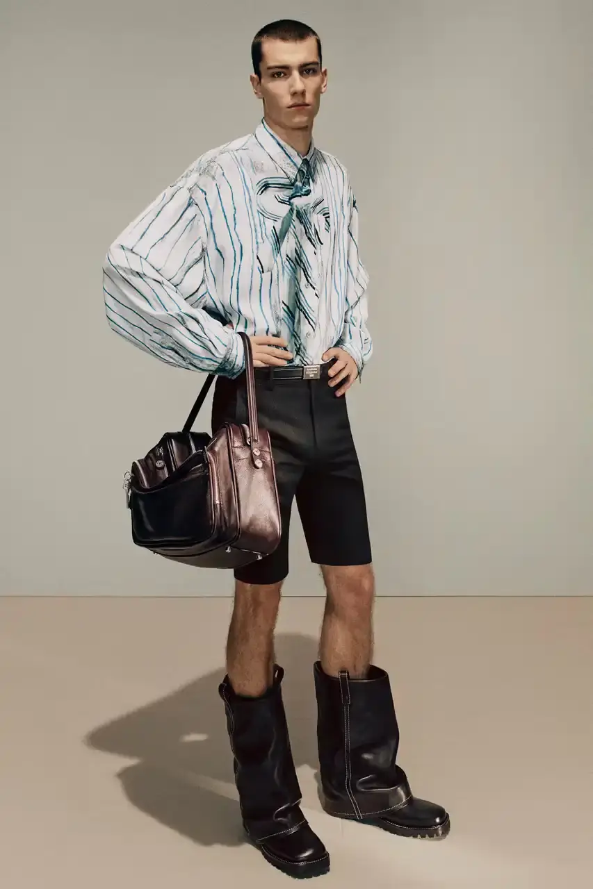 Acne Studios Male model wearing a gray tweed jacket over pink athletic tank top, paired with blue jeans and heart-shaped Acne Studios belt buckle (image 10 of 24)