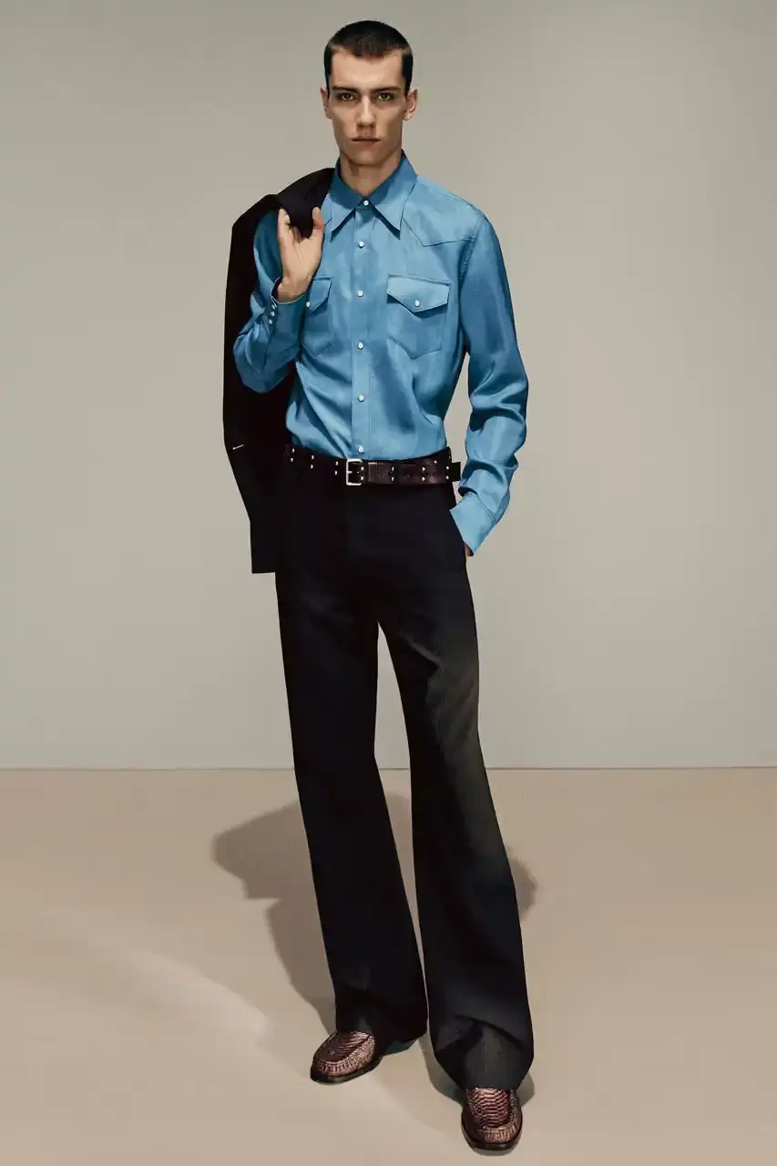 Acne Studios Male model wearing a gray tweed jacket over pink athletic tank top, paired with blue jeans and heart-shaped Acne Studios belt buckle (image 12 of 24)